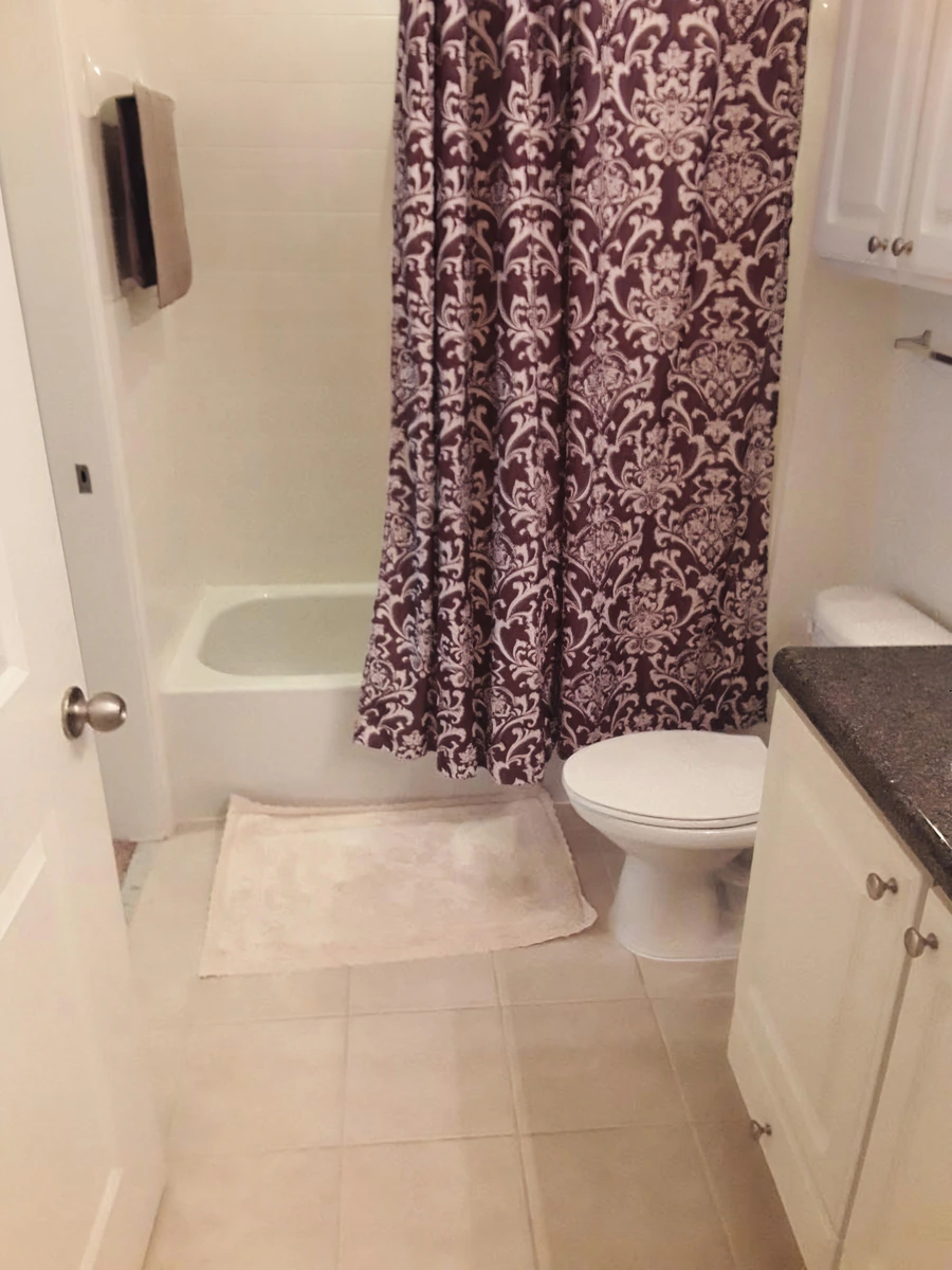 Clean bathroom with vanity, mirror and shower in a furnished Simpsonville apartment