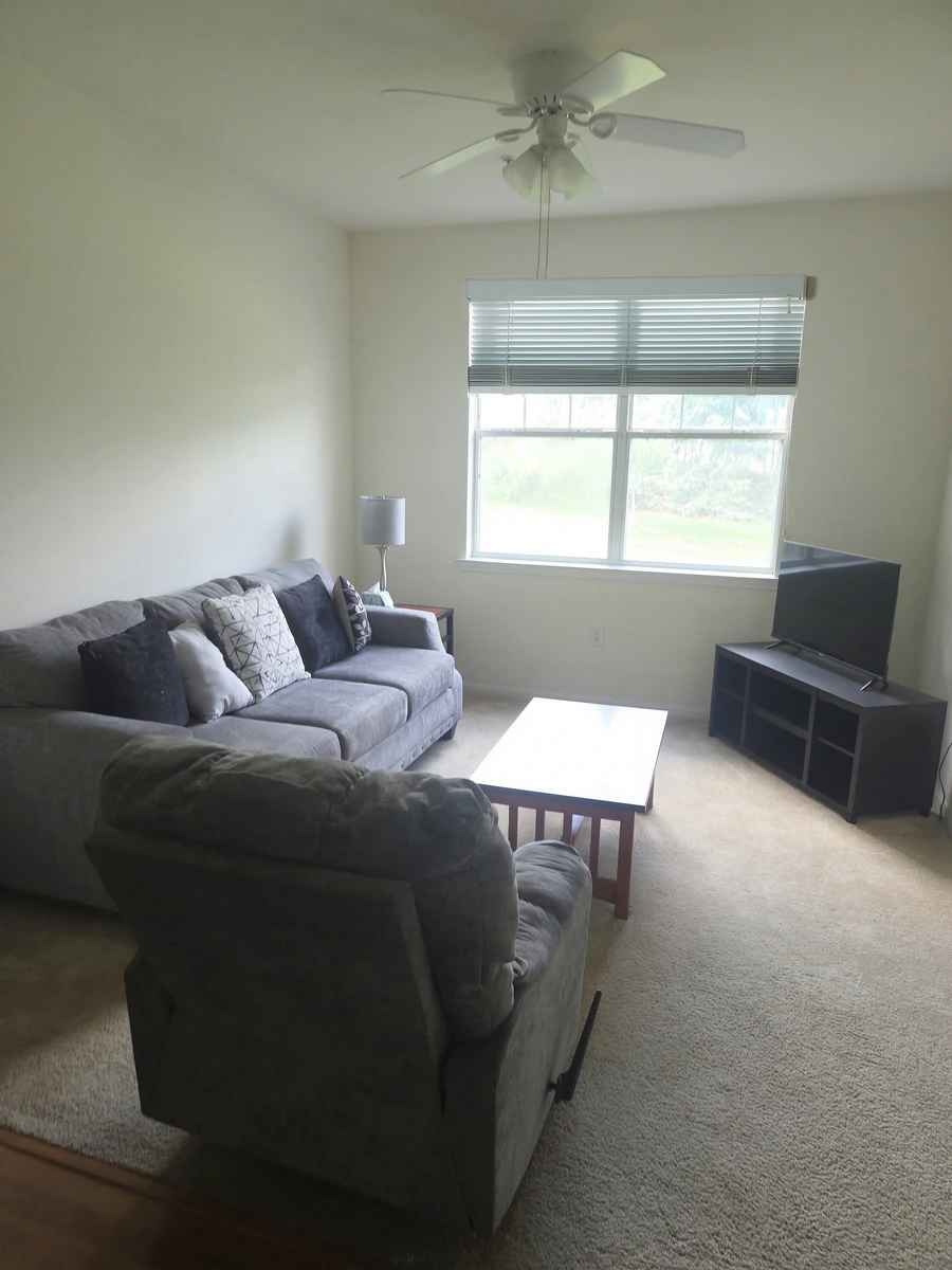 Furnished living area with a sectional sofa, recliner, coffee table and television